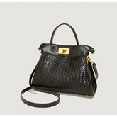 Black woven handbag with gold accents on a light gray background